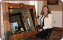 Jane Bash posing next to a large mirror with leather boot frame